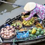 Floating Markets - Photo of Person Selling Fruits While Standing on Boat
