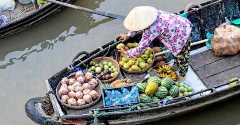 Floating Markets - Photo of Person Selling Fruits While Standing on Boat