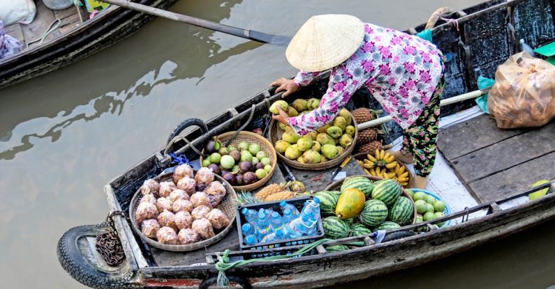 Floating Markets - Photo of Person Selling Fruits While Standing on Boat