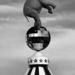 Art Themes - Black and white statue of elephant standing on hind legs on glitter ball placed on circus big top on overcast day