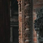 Temple Etiquette - A close up of a carved stone wall with a statue