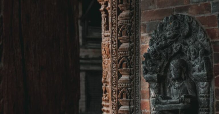 Temple Etiquette - A close up of a carved stone wall with a statue