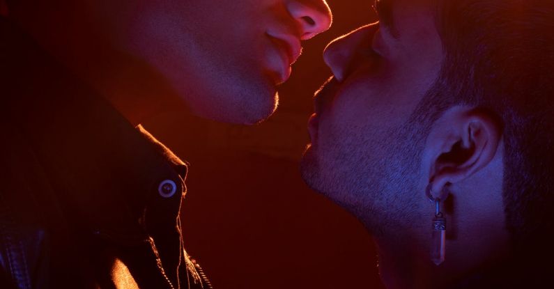 LGBTQ+ - Two men kissing in front of a bright light