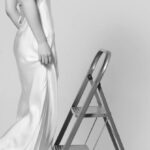 Thai Silk - A woman in a white dress is standing on a ladder