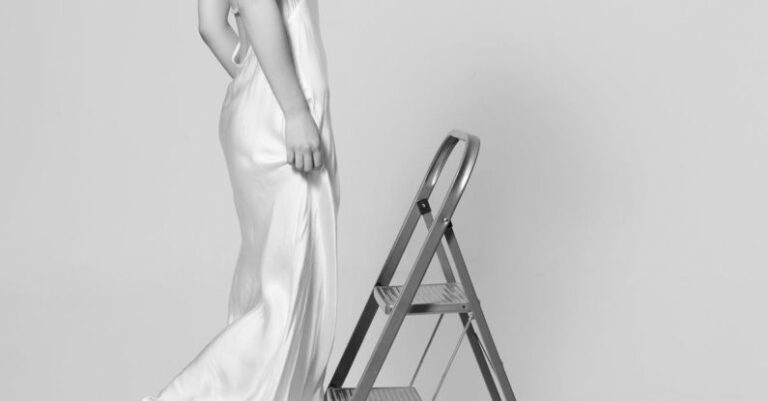 Thai Silk - A woman in a white dress is standing on a ladder