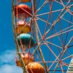 Urban Adventures - A ferris wheel with colorful balls against a blue sky