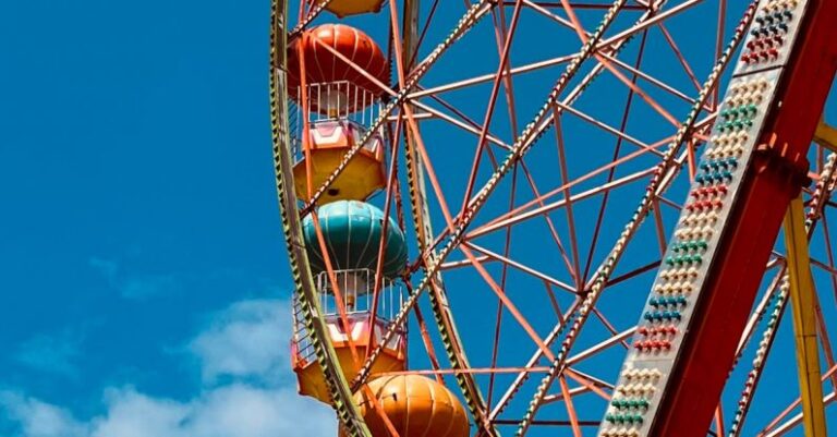 Urban Adventures - A ferris wheel with colorful balls against a blue sky