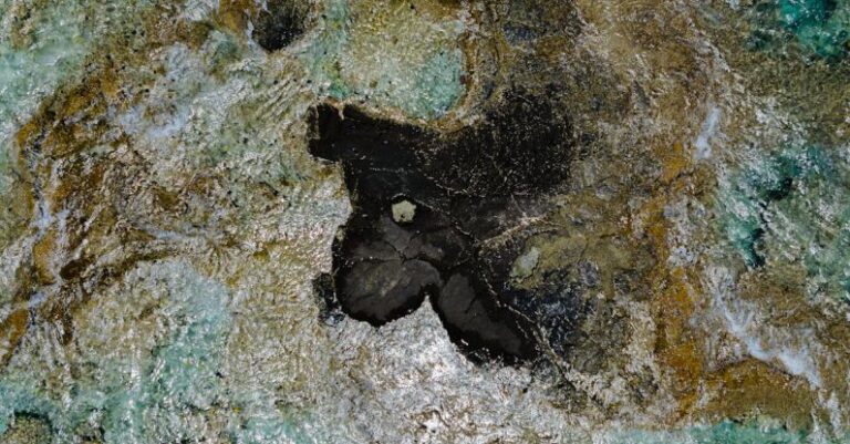 Cheap Travel - A small black rock in the middle of the ocean